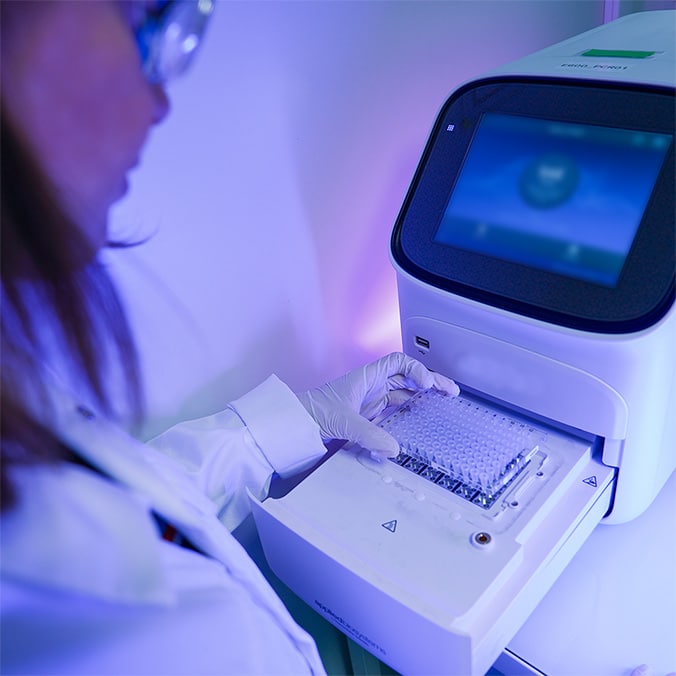 Une technicienne de laboratoire observe des échantillons sur une machine.